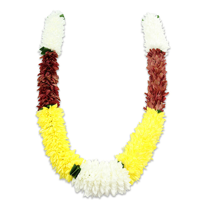 Set against an even white background, this U-shaped traditional mala is a study in colour-blocked elegance and artisanry. Each arm mirrors the other, beginning with a dense, cylindrical run of creamy white, chrysanthemum-esque fabric blossoms that give a soft, cloud-like texture at the top. Beneath these, a concentrated band of maroon or deep reddish-brown provides a solemn, grounding contrast-the small, compact petals layered so the band reads almost velvety despite being synthetic. The garland's most expansive section is a long, vibrant sweep of bright yellow flowers, arranged so densely that the arc appears plush and sculptural, as though stitched from sunlight. At the lowest point where both arms converge, a prominent cluster of pure white blooms-broader and slightly larger-forms the central focal rosette, balancing the composition and emphasizing ritual significance. Tiny dark green leaf-like accents are positioned at key colour junctions, notably between yellow and the lower white cluster, adding a measured touch of natural punctuation. The craftsmanship is evident: thousands of fabric petals, each placed to mimic natural blossoms while providing the resilience needed for repeated use in Hindu pooja, temple processions, or as wedding garlands. This style is familiar in Chinatown markets off Wardour Street and Gerrard Street, where florists craft ceremonial pieces for local families and restaurateurs; its colours-white for purity, yellow for prosperity, maroon for devotion-make it instantly appropriate for festive, religious, and decorative purposes alike.
