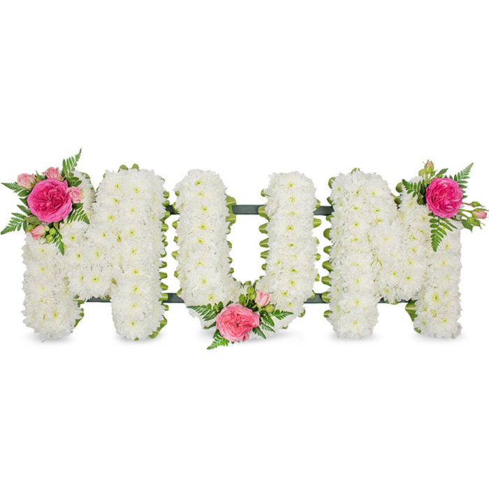 A beautifully composed floral display spells out MOM in large, capital letters, each one crafted with meticulous attention typical of a specialist florist working in the heart of Chinatown. The letters stand evenly spaced against a plain white background that highlights the shape and colour of every bloom. Each character is fully blanketed with small white chrysanthemums or similar dainty flowers, their compact, rounded heads set shoulder to shoulder so that the surface appears uniform, soft, and slightly raised. The flowers create a comforting cushion of white, suggesting purity, remembrance, and the quiet strength often associated with motherhood. At the base of the letters, a dark green supporting frame is glimpsed, with a coordinating ribbon or edging that cleanly defines the lower line of the tribute and ensures it remains stable when displayed at a funeral home or memorial hall nearby. Adding touches of warmth and tenderness, three rose and foliage clusters are artfully positioned on the arrangement. The first rests at the top left of the opening M, featuring a deep fuchsia rose and paler blush-pink roses, mingled with fine, ferny greenery. Another cluster lies low, between the O and the last M, partially overlapping both letters and drawing them together with a gentle ribbon of colour. The final group decorates the upper right of the closing M, mirroring the first and giving the arrangement visual harmony. You can imagine this tribute delivered by a local Chinatown florist to a family ceremony, its harmonious combination of white, pink, and green offering solace, honouring a mother's legacy, and expressing heartfelt thanks in the universal language of flowers.